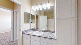 a bathroom featuring a granite countertop vanity, a large mirror, and ample storage space