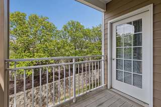 A balcony with a white door and a metal railing.