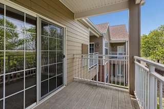 A balcony with a sliding glass door and a railing.