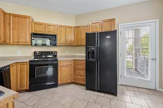 A kitchen with black appliances and wooden cabinets.