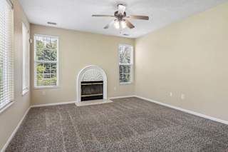A room with a fireplace and a ceiling fan.