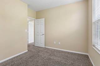 A room with a carpeted floor and a white door.