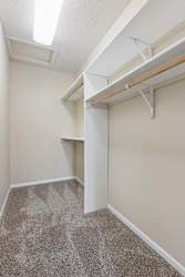 A large walk-in closet with built in shelving.