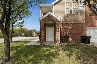 A villa with a brown brick facade and a white door.
