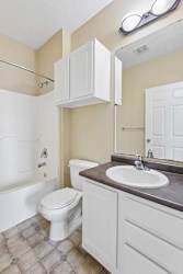 A white toilet sits in a bathroom next to a sink.