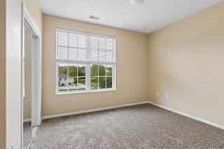 A room with a large window and a carpeted floor.