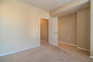 A room with a white door and carpeted floor.