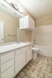A white bathroom with a toilet, sink, and bathtub.
