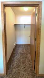 a long walk-in closet with built-in shelving