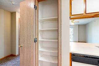 Built-in pantry with multiple shelves, adjacent to the kitchen and living area.