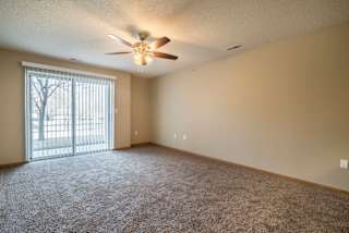 A room with a ceiling fan and carpeted floor.