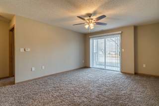 A room with a ceiling fan and carpeted floor.