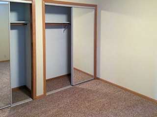 a bedroom with two closets with sliding mirror doors