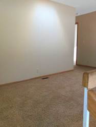 a carpeted loft area with a small hallway leading to a bedroom and bathroom