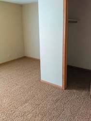 a bedroom with a carpeted floor and a walk-in closet