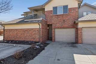 Front exterior of multi-level brick townhome with private garage entrance.