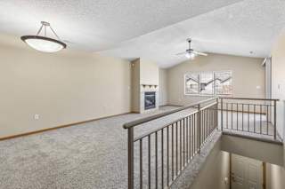 Open-concept living area with fireplace, vaulted ceiling, and natural light.