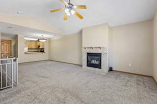 Large living room with gas fireplace, vaulted ceilings, and open floor plan.