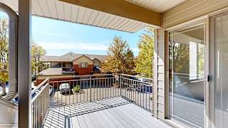 a balcony with a metal railing that faces another apartment building