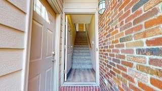 a front door leading into an apartment staircase adjacent from a door to an attached garage