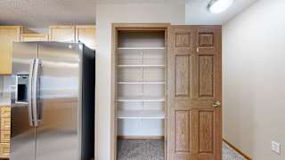 a kitchen with a stainless steel refrigerator and a pantry