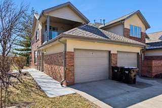 Townhome exterior with attached garages, brick façade, and shared driveway.