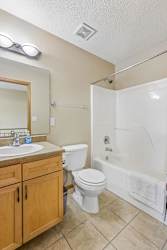 A bathroom with a white toilet, sink, and bathtub.
