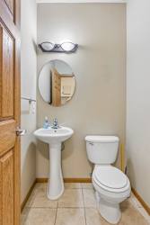 Apartment powder room with pedestal sink, framed mirror, neutral walls, and convenient main-level location.