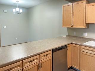 a kitchen with wooden cabinets and stainless steel appliances