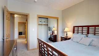 a bedroom with a bed and a mirrored closet door
