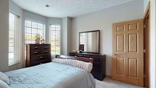 a bedroom with a bed and a dresser and a mirror
