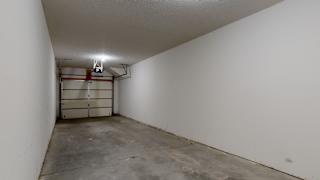 the inside of a garage with a white wall and a garage door