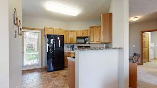 a kitchen with an island and a black refrigerator