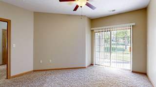 a bedroom with a sliding glass door to a patio with vertical blinds and a ceiling fan