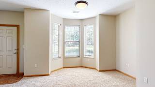 a living or dining room with three windows and a door