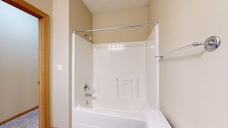 a bathroom with a shower tub and a wall-mounted towel rack