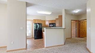 a kitchen with a bar top counter and a black refrigerator