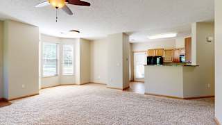 a living room featuring a windowed dining area adjacent to a kitchen