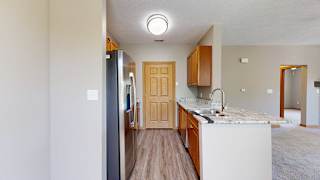 a galley kitchen with granite counter tops and stainless steel appliances
