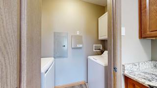 a laundry room with a washer and dryer and overhead storage