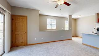 a living room with a coat closet and a half wall that oversees the entryway stairs
