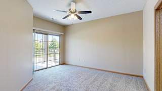 a bedroom with a ceiling fan and sliding glass door to a balcony