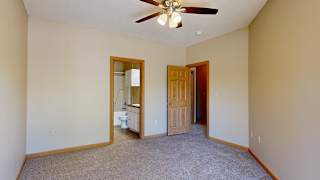 a bedroom with a ceiling fan and attached bathroom