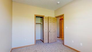 a bedroom with a closet and a door to a hallway