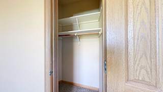 a closet with a door and built in shelving