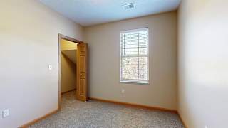 a bedroom with a window and a door to a walk-in closet
