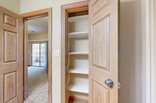 A bathroom with a linen closet, with several built-in shelves.