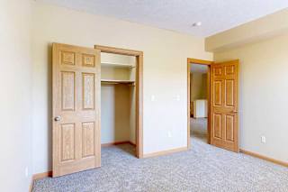 A bedroom with a walk-in closet and a door to the living room.