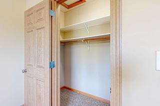 A wide walk-in closet with overhead shelves, and hanging space.