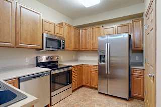 A kitchen with wooden cabinets and stainless steel appliances.